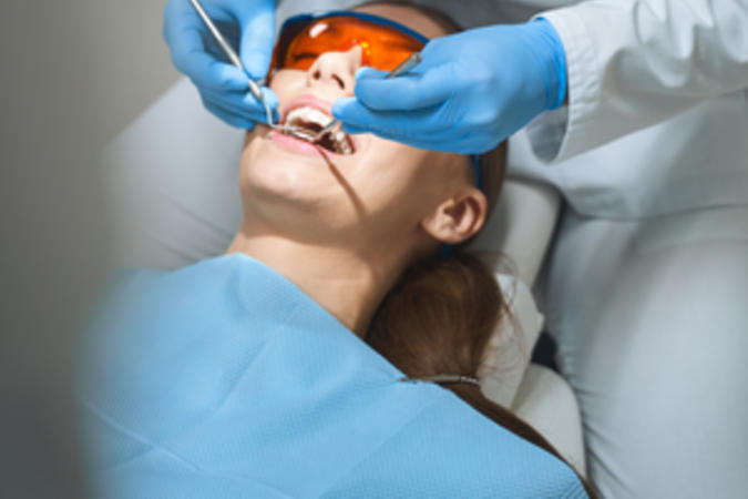 An endodontist performing a root canal using a dental microscope.